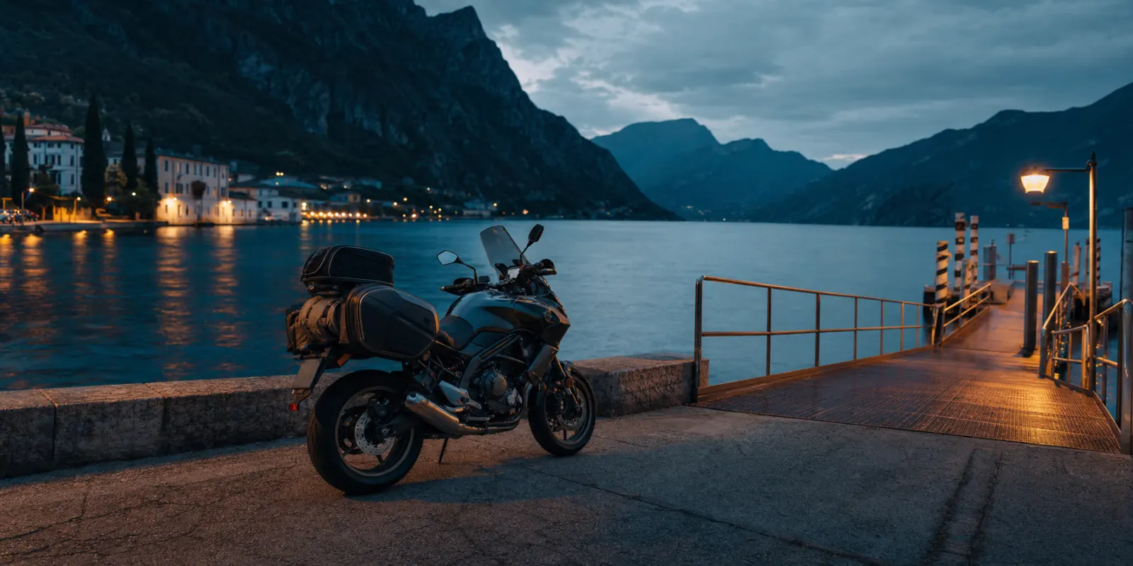 Moto touring parcheggiata su un pontile del Lago di Garda al tramonto